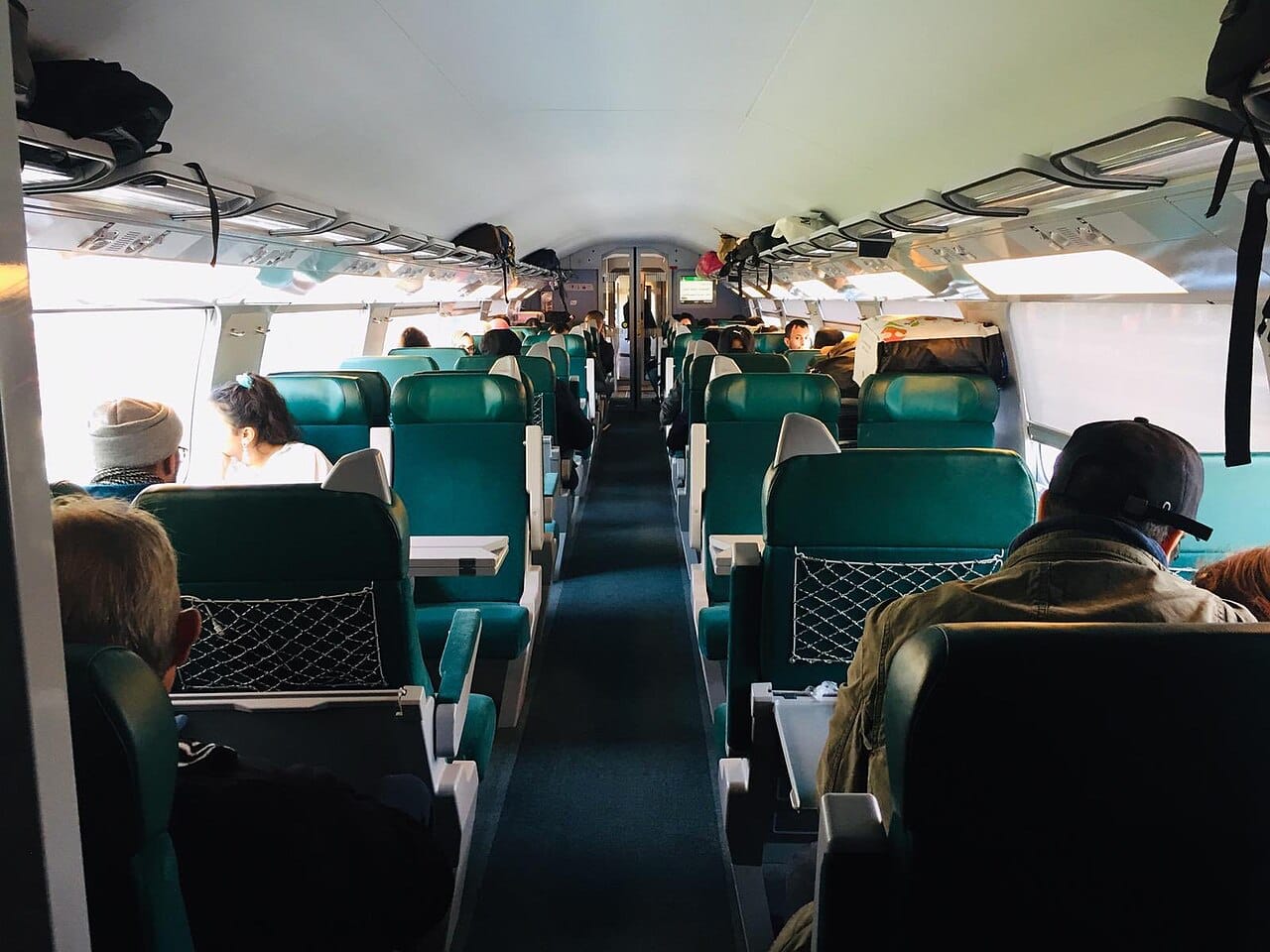 The second-class interior of an Al Boraq trainset, showing rows of upholstered seats and overhead luggage racks