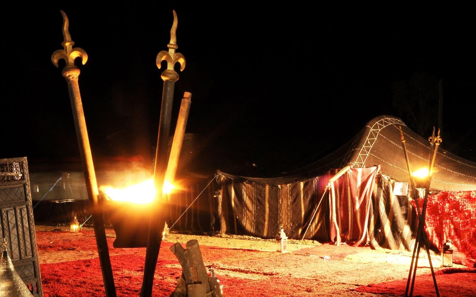 A torch-lit Berber camp at night, the version of the desert that appears in the listing photographs