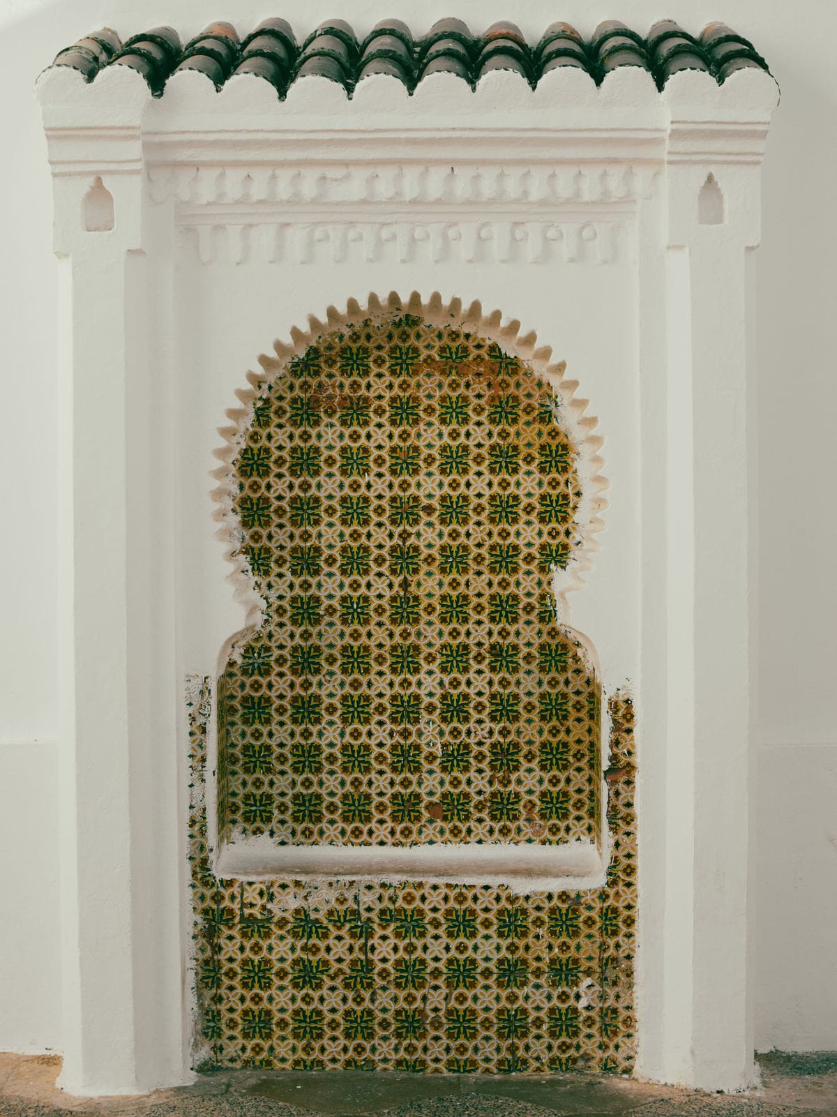 A wall of traditional Moroccan zellige mosaic tilework in geometric patterns