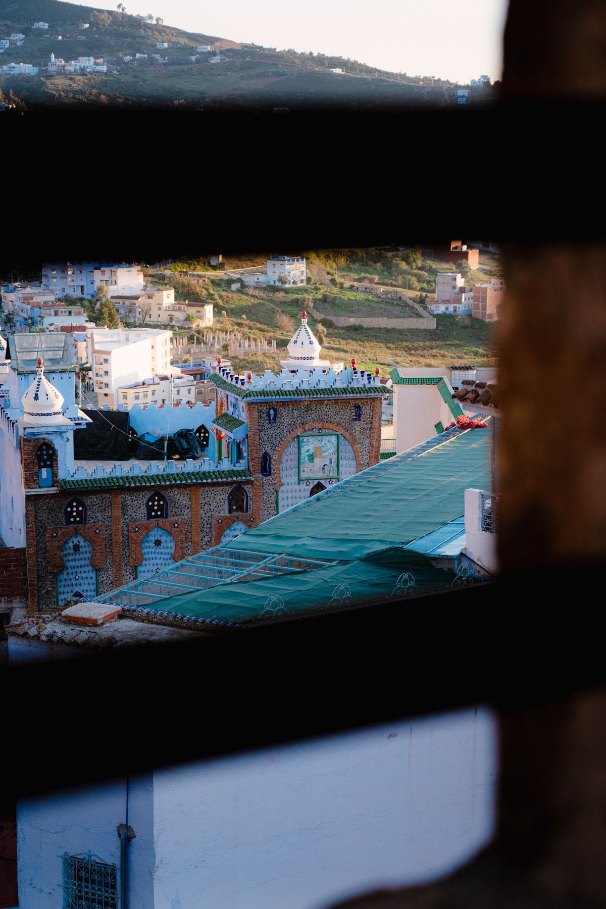 A view over the rooftops of a Moroccan town seen through a window