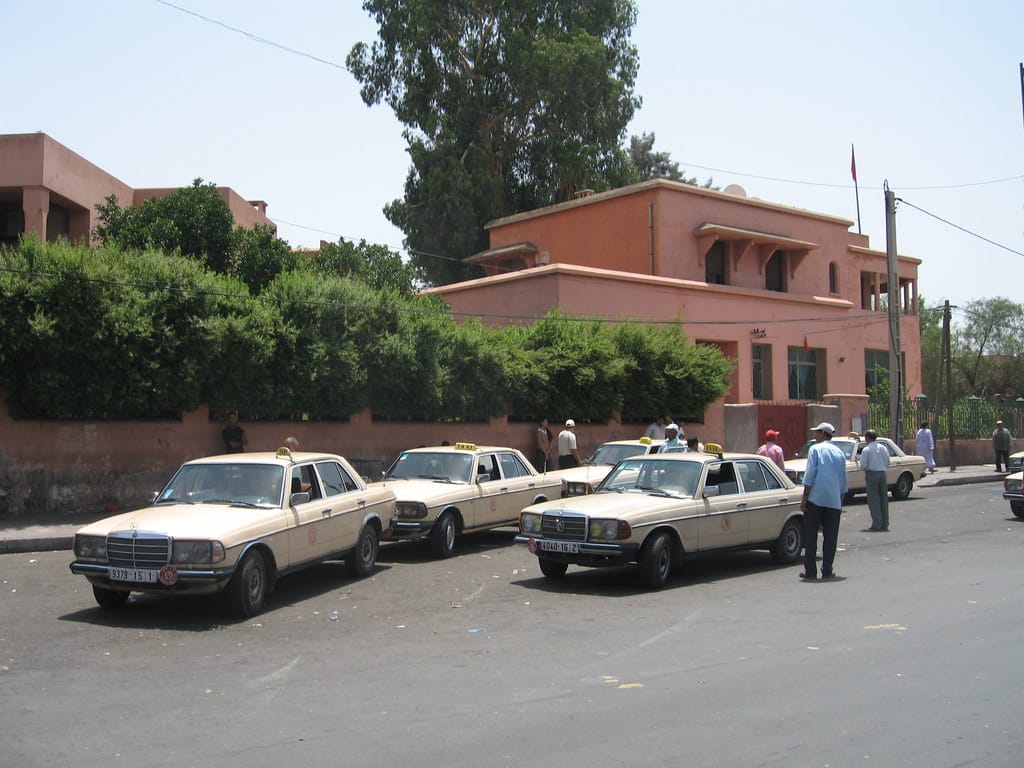 Beige petit taxis waiting at a rank in Marrakech: the metered city cabs