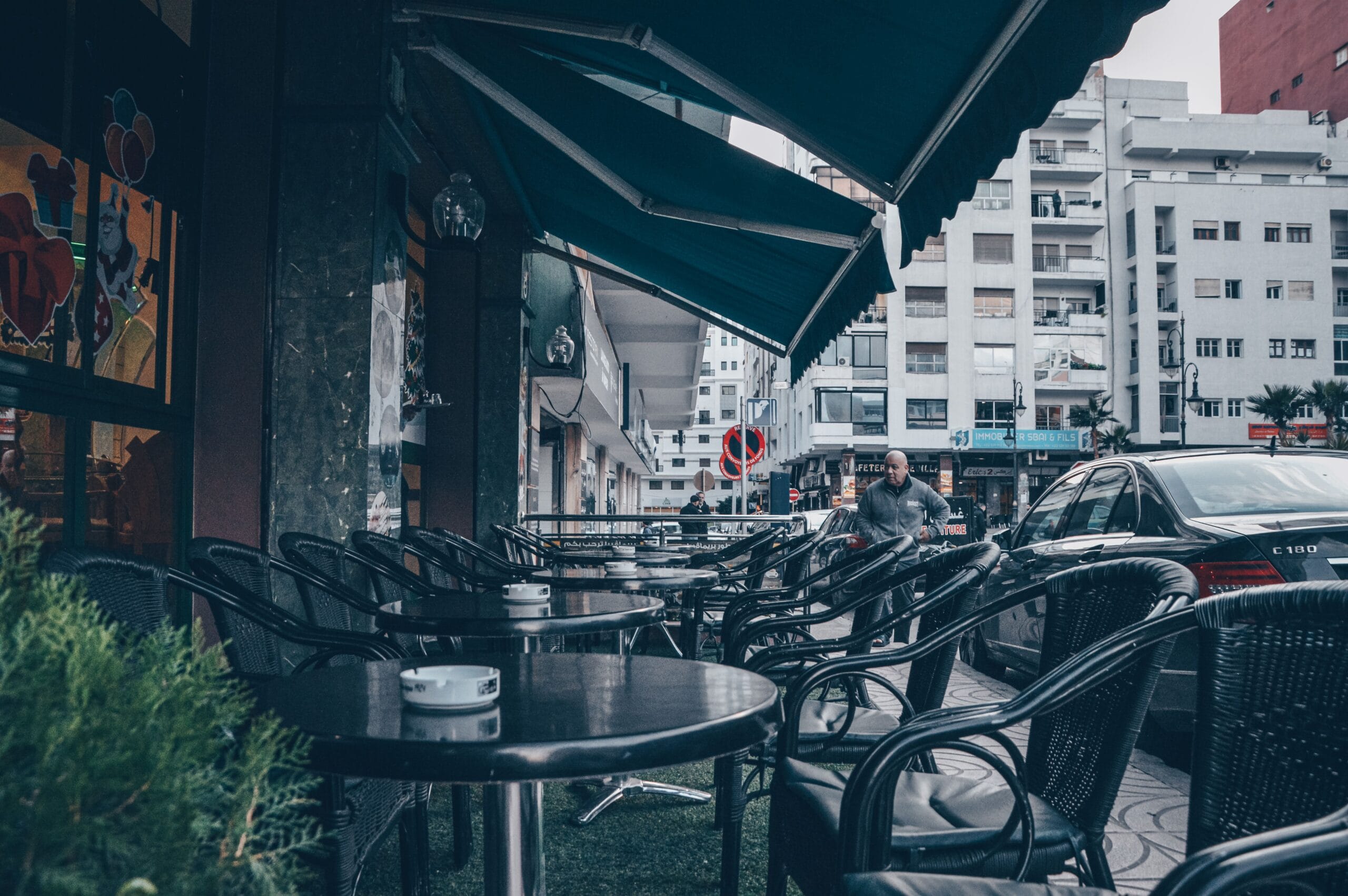 Wicker chairs and tables under a canopy in the Tangier café district